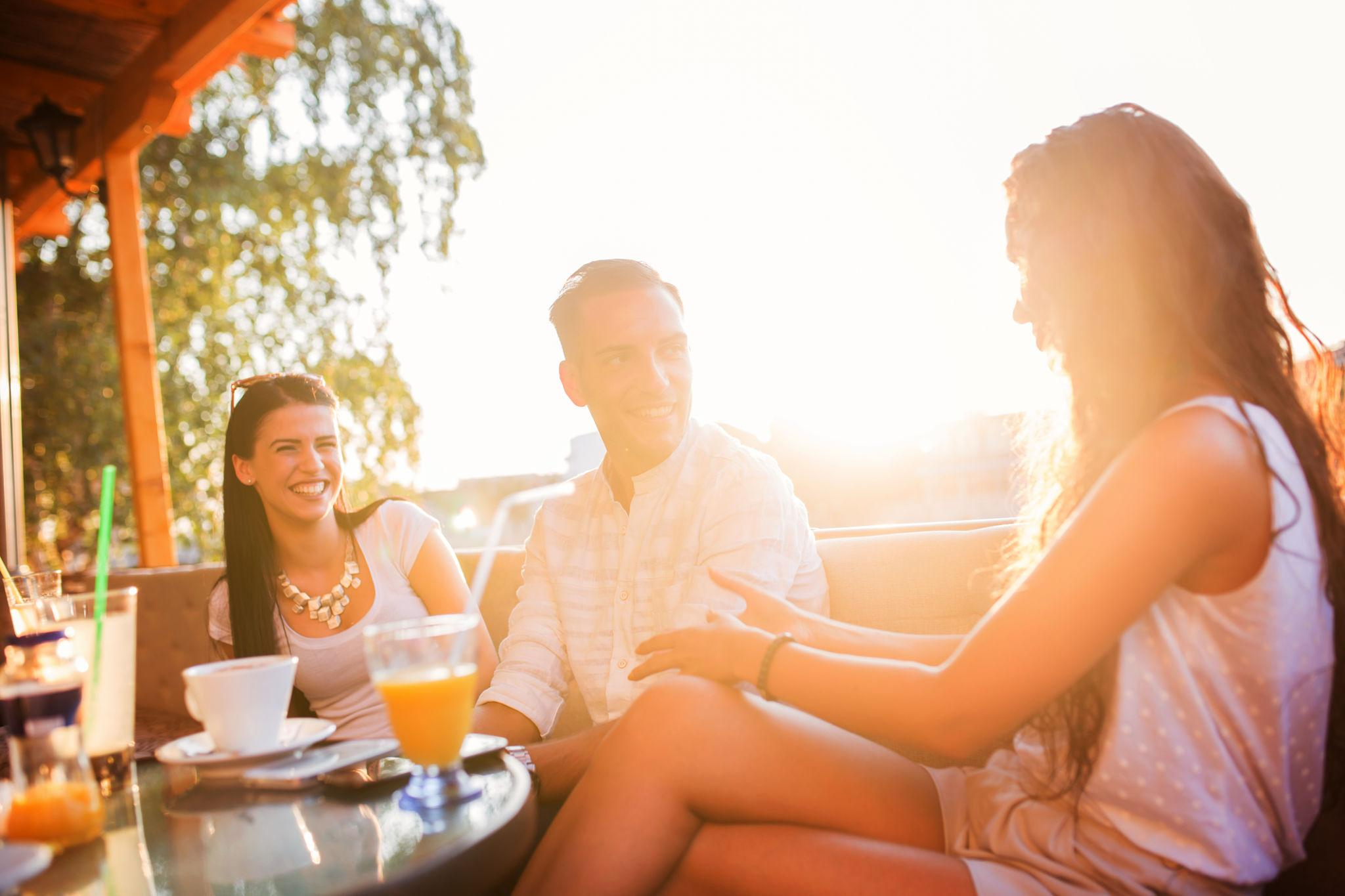 Adults socializing outdoors at sunset, lifestyle blog cover